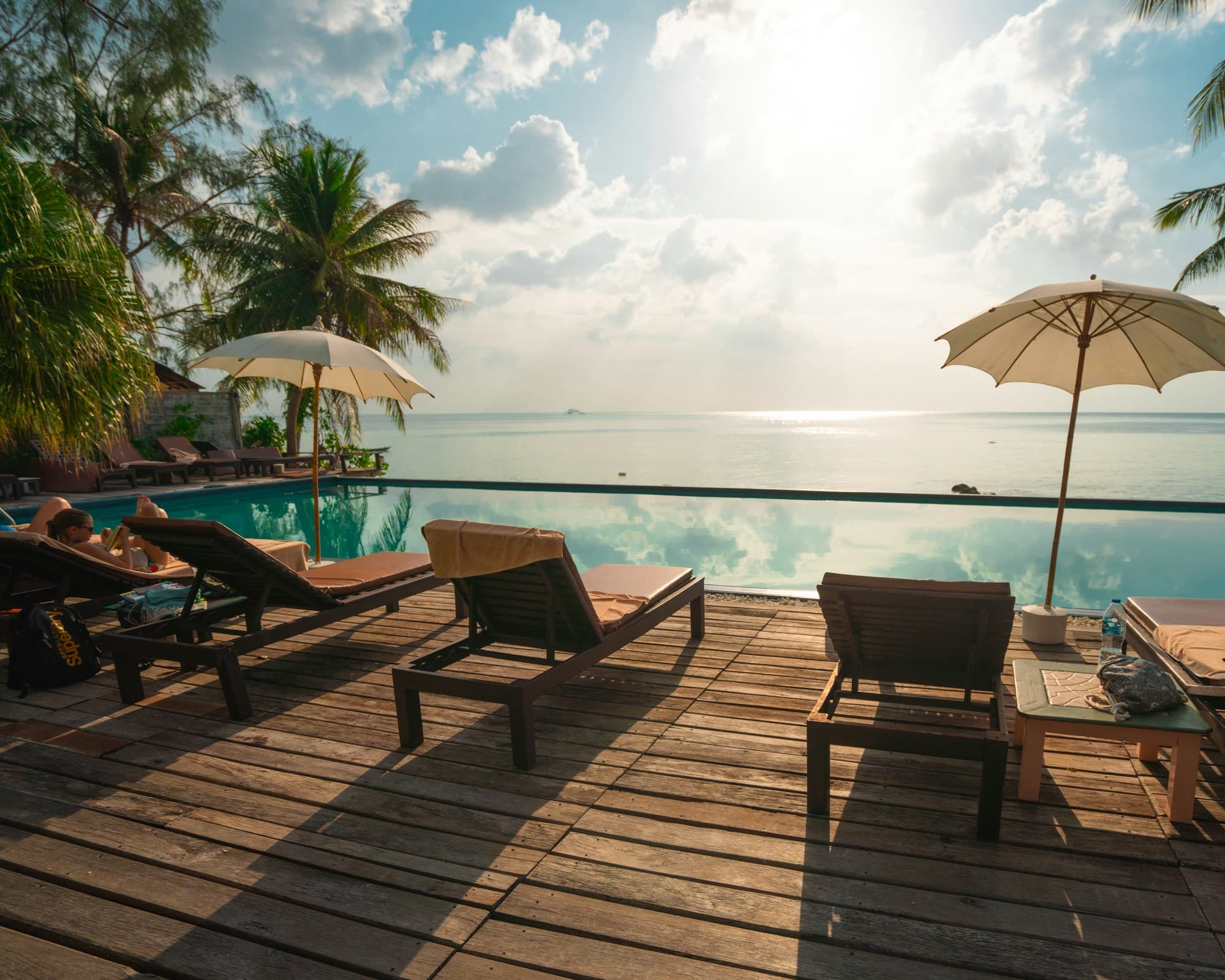 Luxury lodge deck with loungers and umbrellas at golden hour