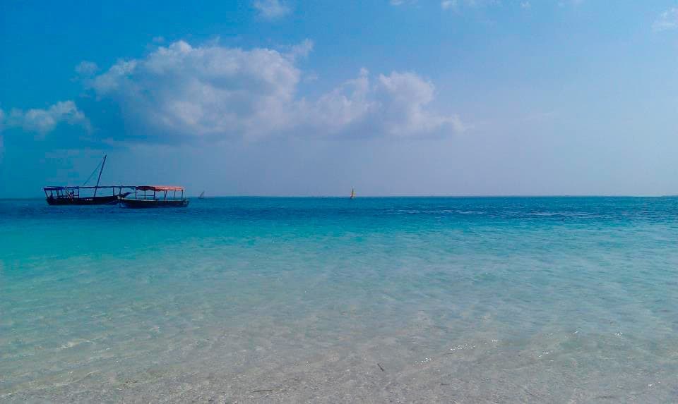 Turquoise water off Nungwi beach with a boat offshore